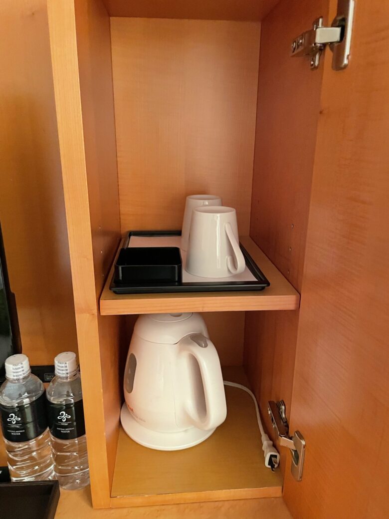 Electric kettle and cups in the cabinet
