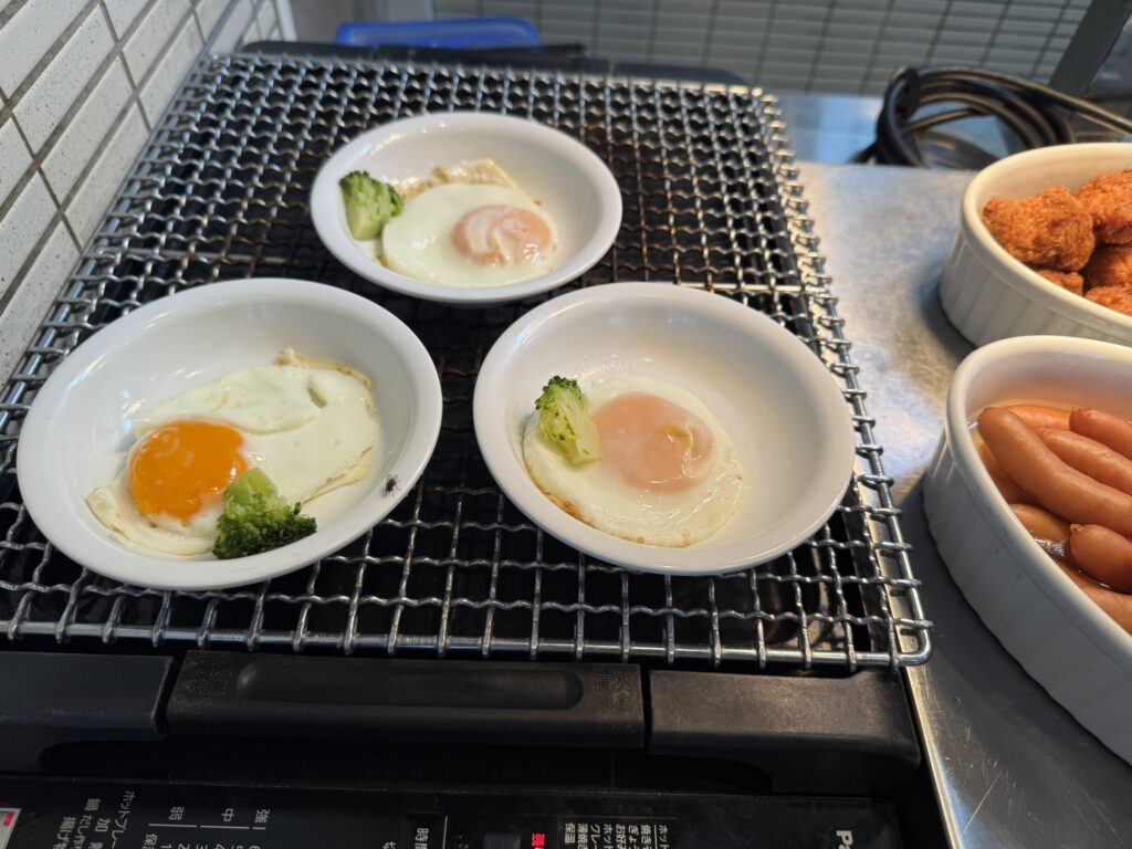ドーミーイン高崎 朝食バイキング ライブキッチンの目玉焼きとソーセージ