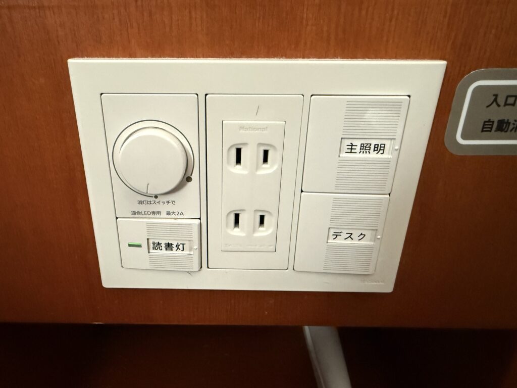 ドーミーイン高崎 客室ベッドの枕元パネルと照明スイッチ・コンセント