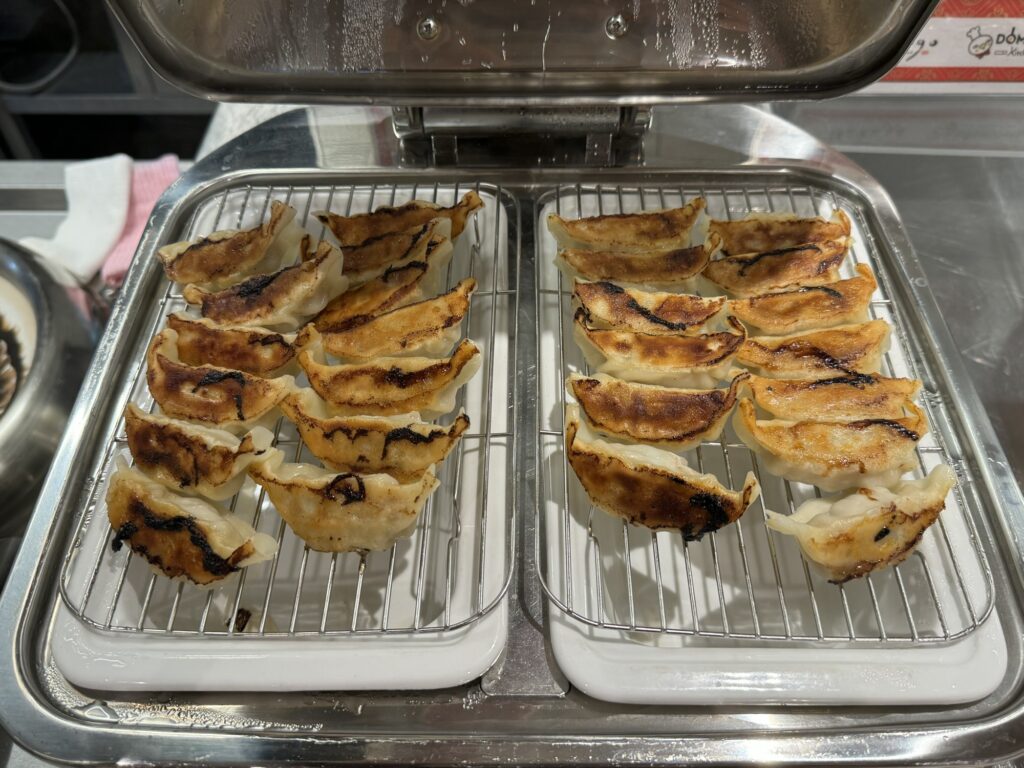 朝食バイキングの焼き立て餃子が並ぶ保温プレート