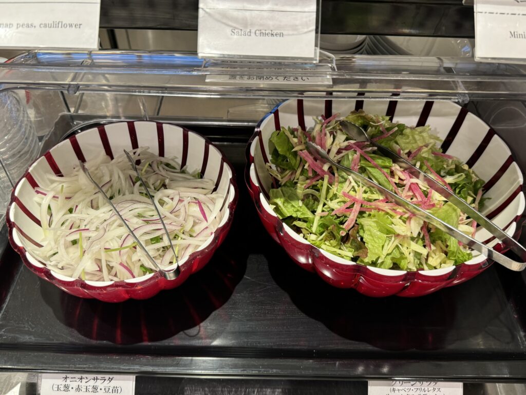 朝食バイキングの新鮮なサラダコーナー。オニオンサラダとグリーンサラダ