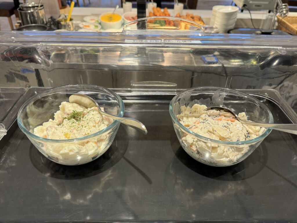 清潔感のあるガラス容器に盛られたポテトサラダなどの和え物コーナー