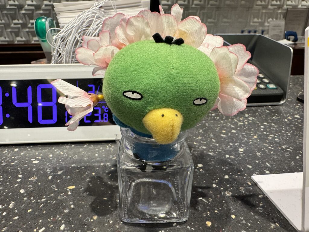 フロントで出迎える、花をあしらった可愛いドーミーいんこのぬいぐるみ