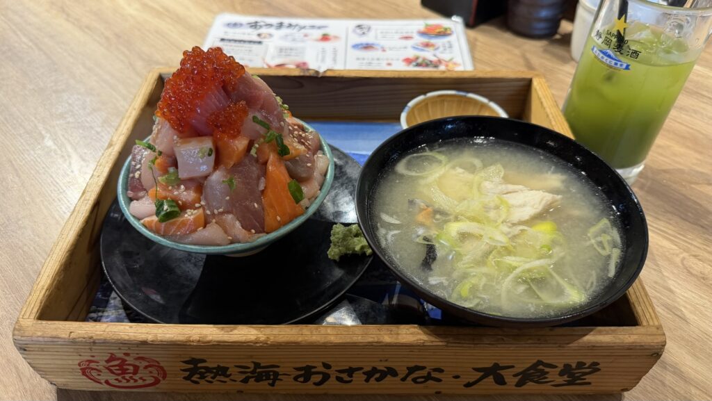 木製のトレイに乗った「海鮮てっぺん丼」とあら汁。器からはみ出すほど魚介が積み上げられている