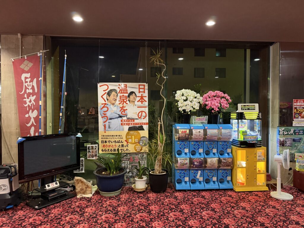 湯ーとぴあ館内の展示コーナー 日本一の温泉をつくるというポスターと造花