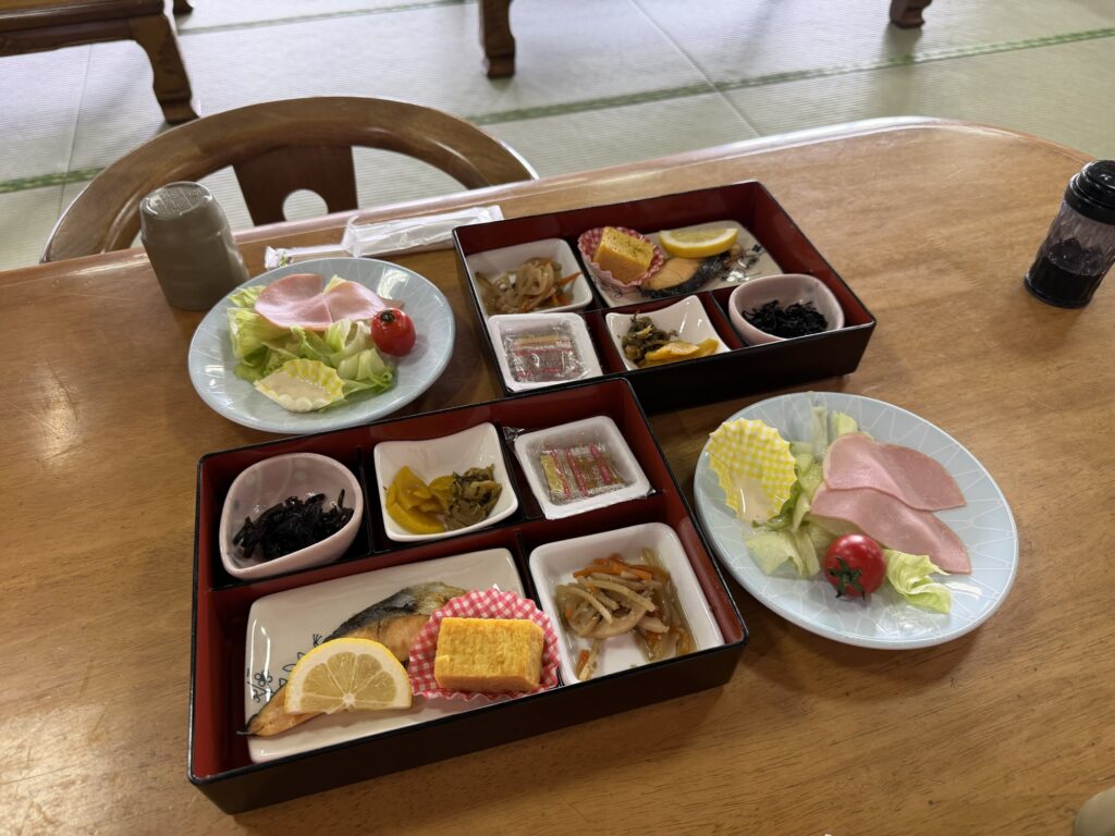 湯ーとぴあの朝食 二人分の和定食の膳が並べられたテーブル