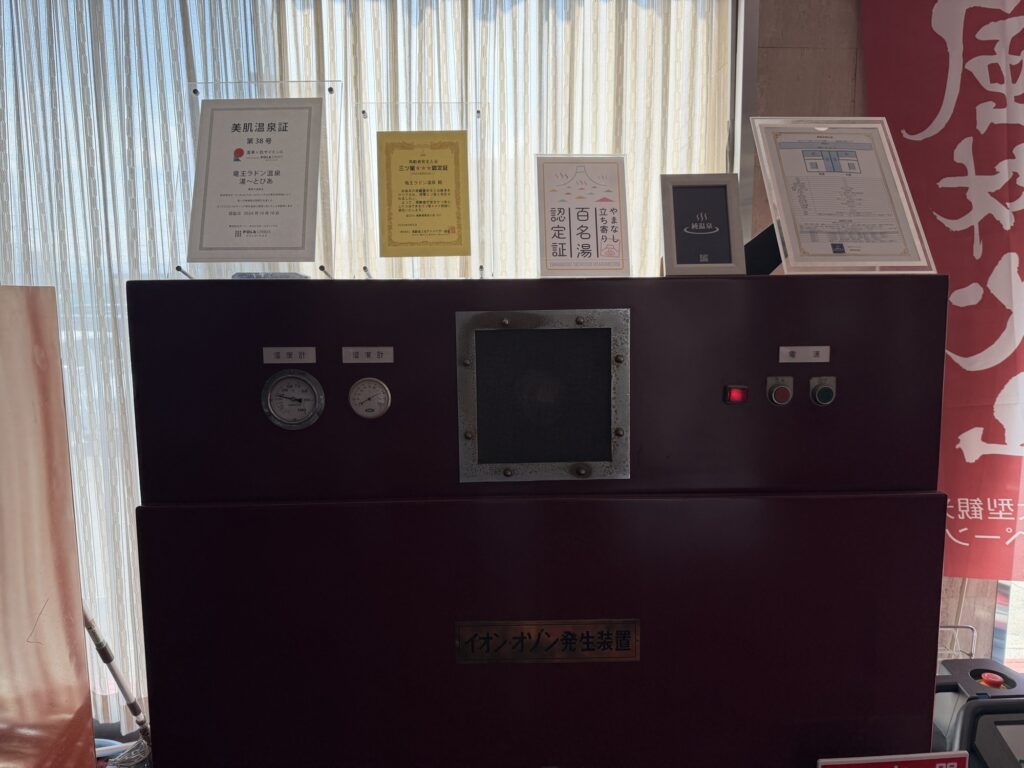 湯ーとぴあのラドン発生装置本体と上部に並べられた認定証