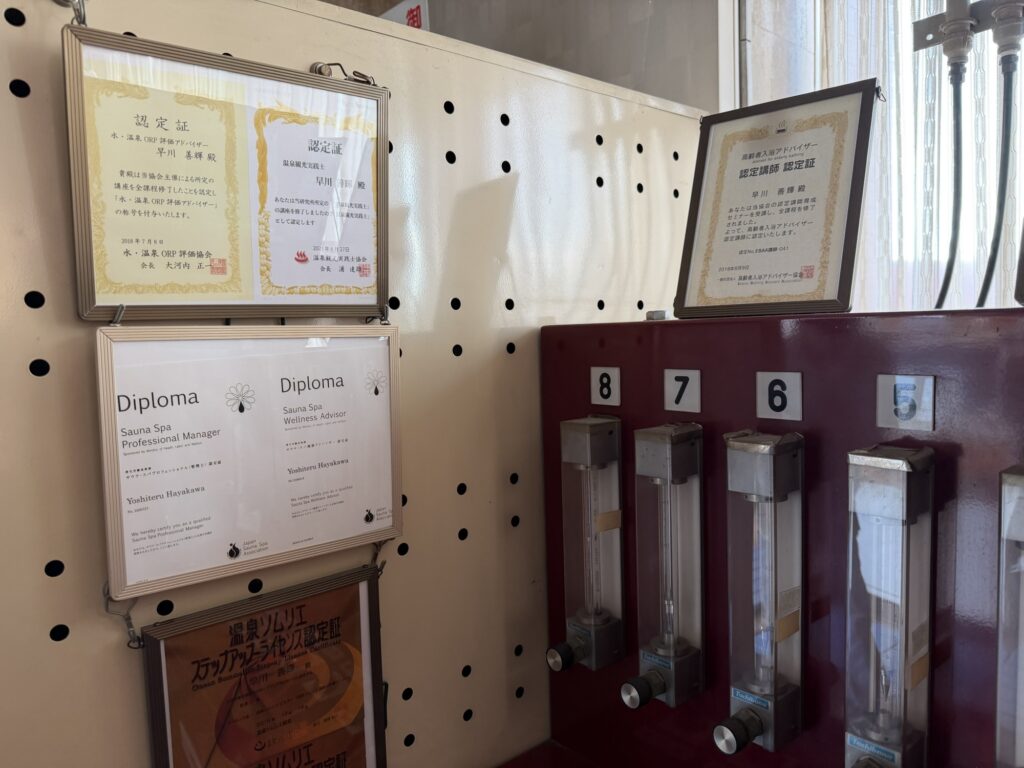 湯ーとぴあのラドン発生装置と壁に掛けられたDiplomaの認定証
