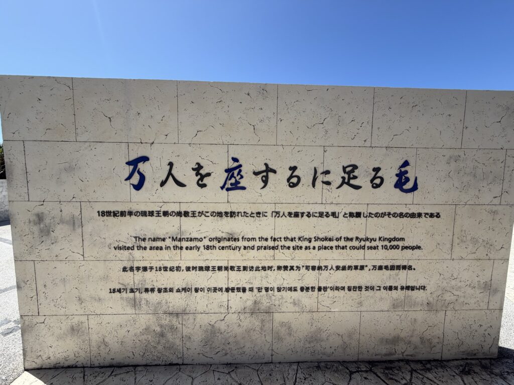 万座毛の名前の由来を4か国語で説明する石碑「万人を座するに足る毛」