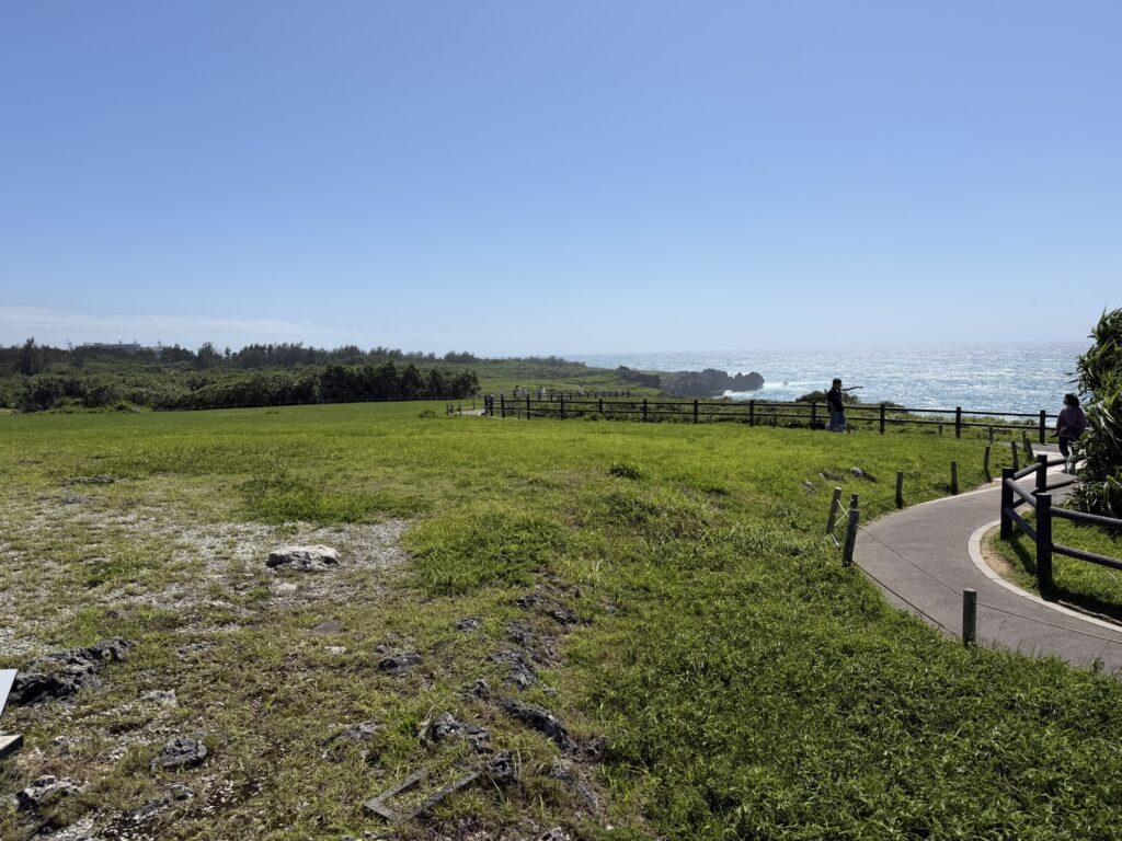 万座毛の遊歩道沿いに広がる芝生広場、家族連れでも歩きやすい平坦な道